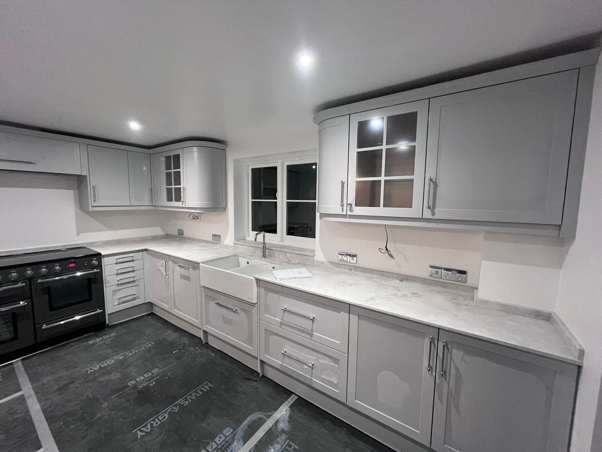 Renovated kitchen with dove-grey shaker cabinetry, marbled worktop and white butler sink